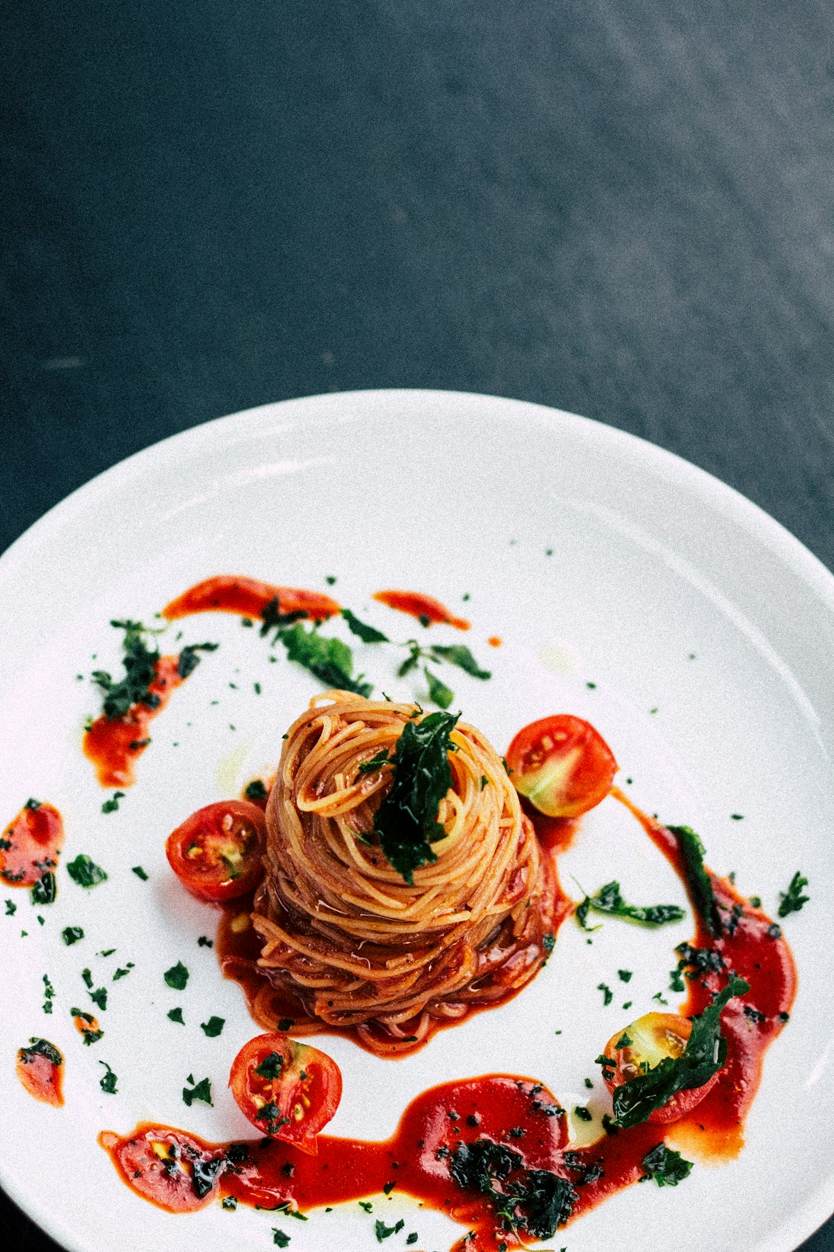 Un plato de pasta con tomate y hierbas, fotografía ilustrativa